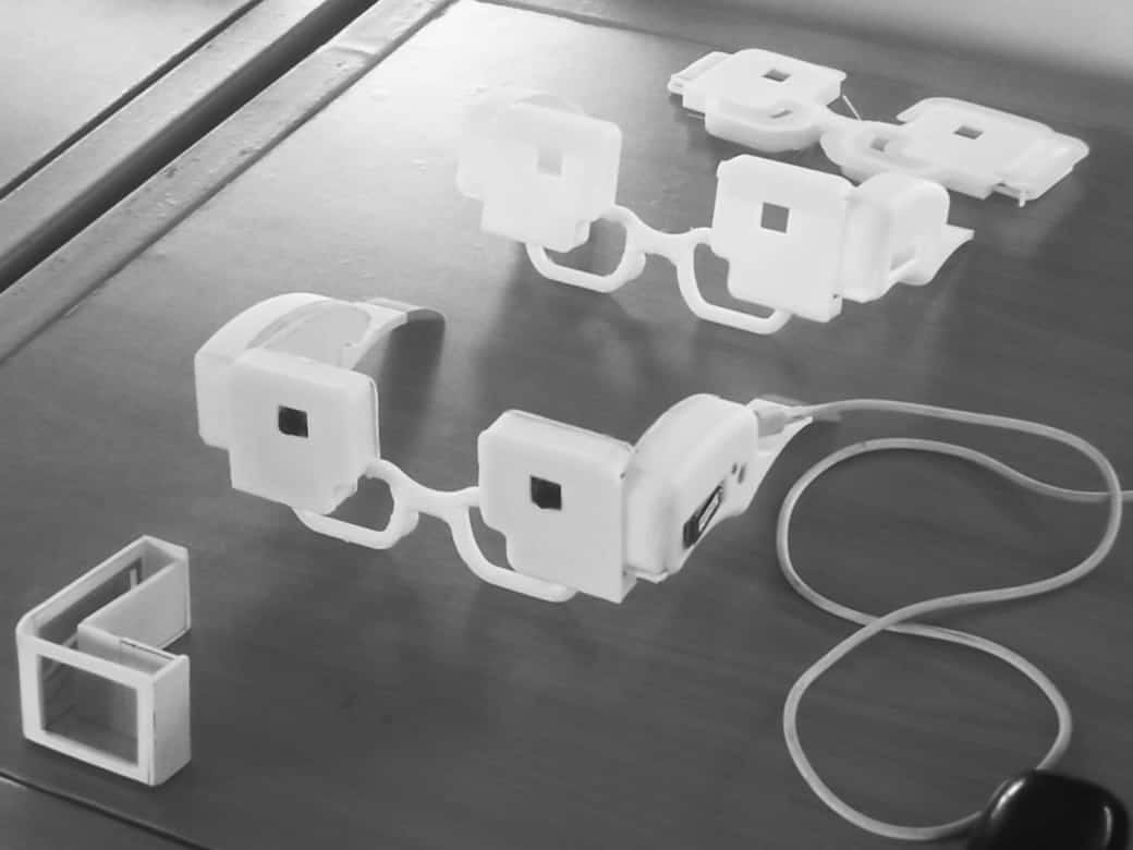 Three 3D-printed smart glasses prototypes on a desk
